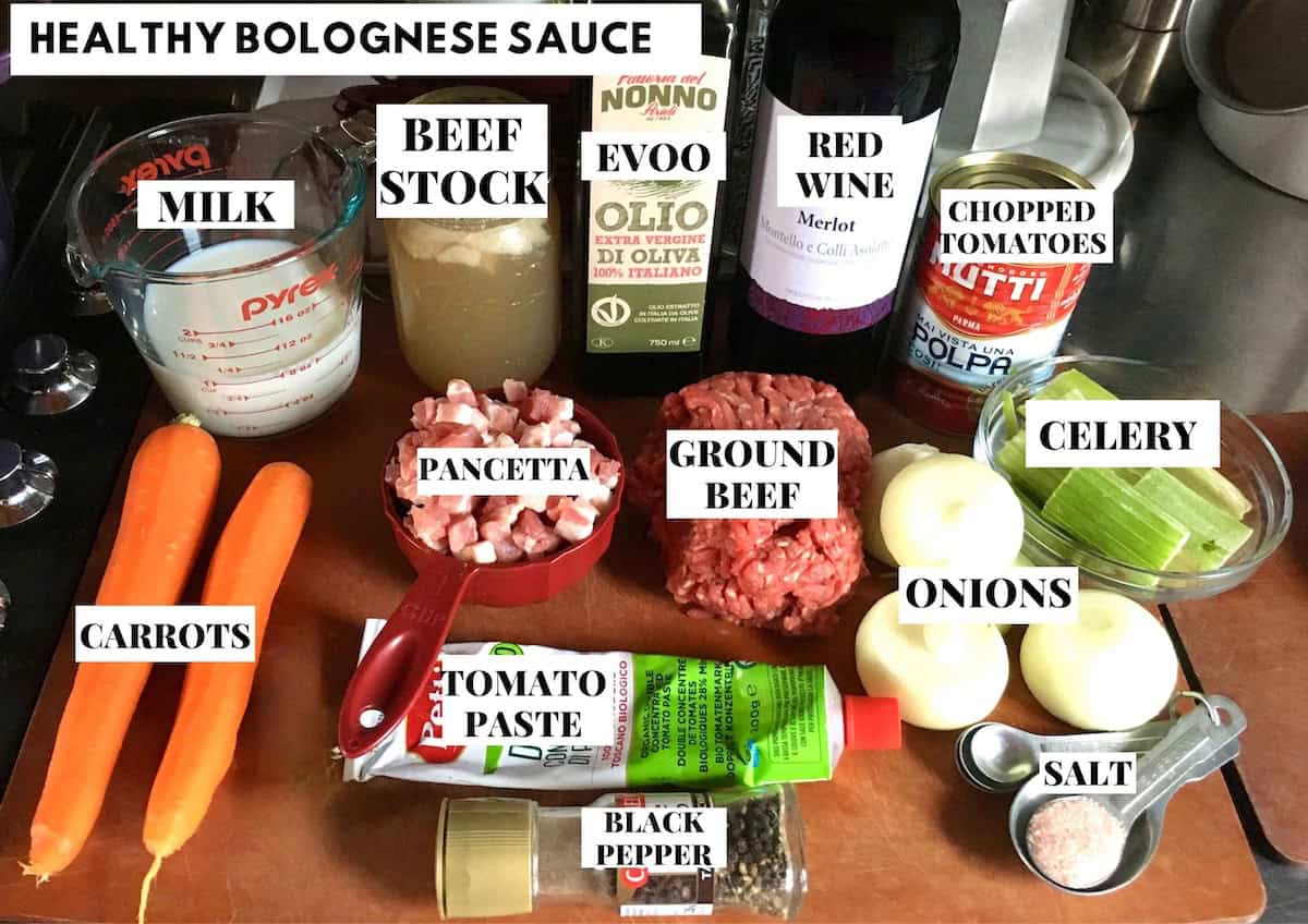 Labeled healthy bolognese sauce ingredients on a sheet pan for a lighter homemade bolognese recipe, easy bolognese sauce made with lean ingredients for a healthy spaghetti bolognese.