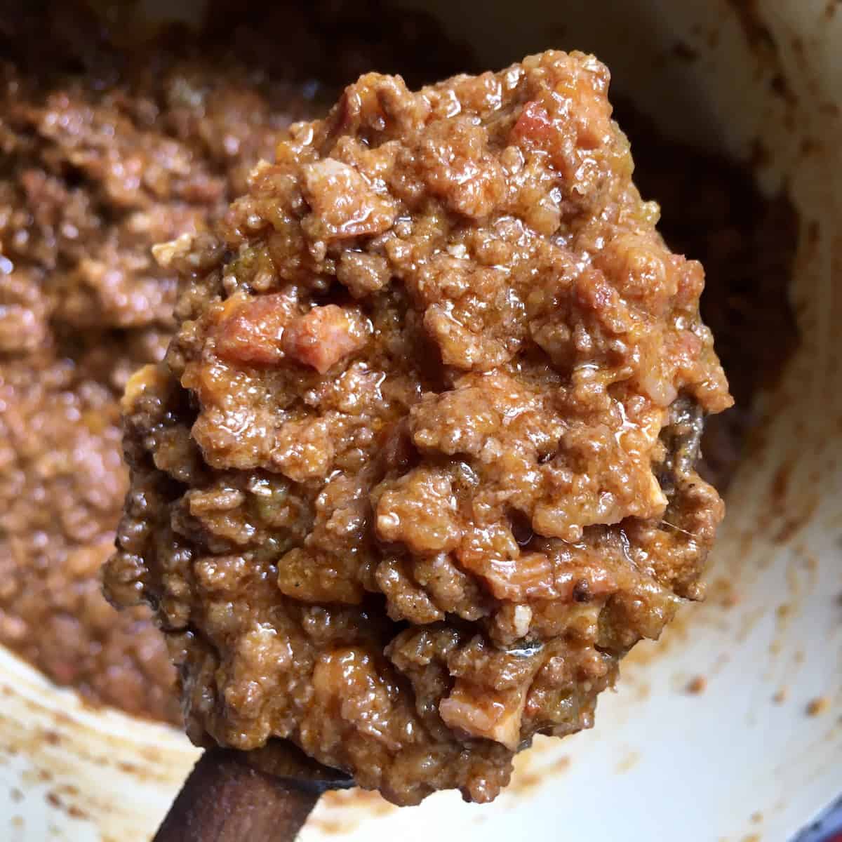 Healthy bolognese sauce on a wooden spoon showing a rich thick texture, healthy bolognese recipe for an easy bolognese sauce made from scratch.
