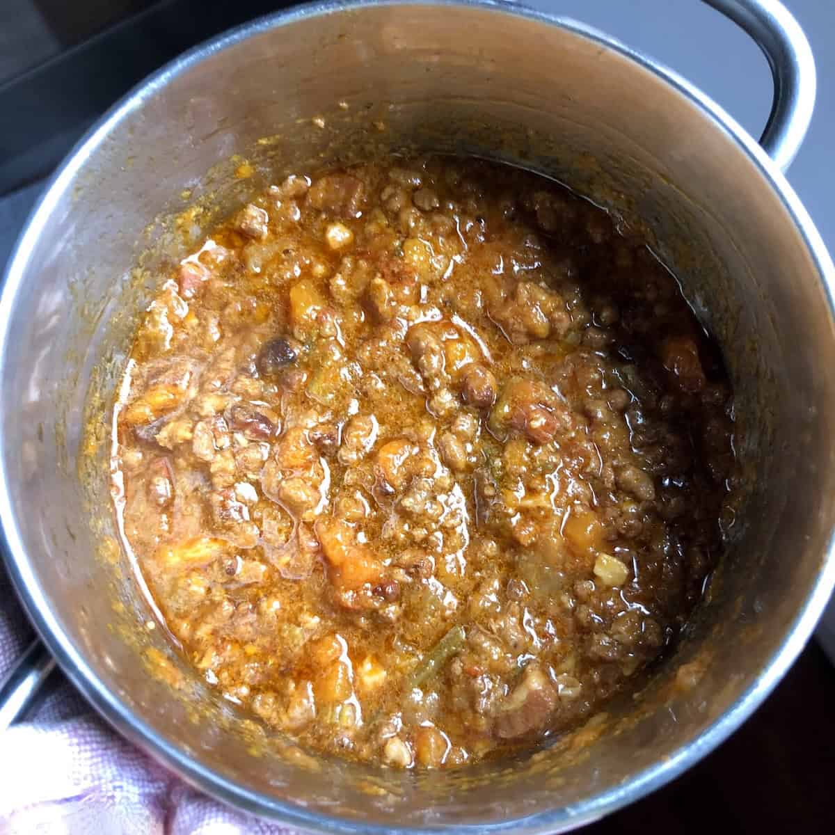 White bolognese sauce finished in a pot ready to serve, white bolognese recipe made from scratch with an easy bolognese recipe using white wine for a lighter Italian ragu.
