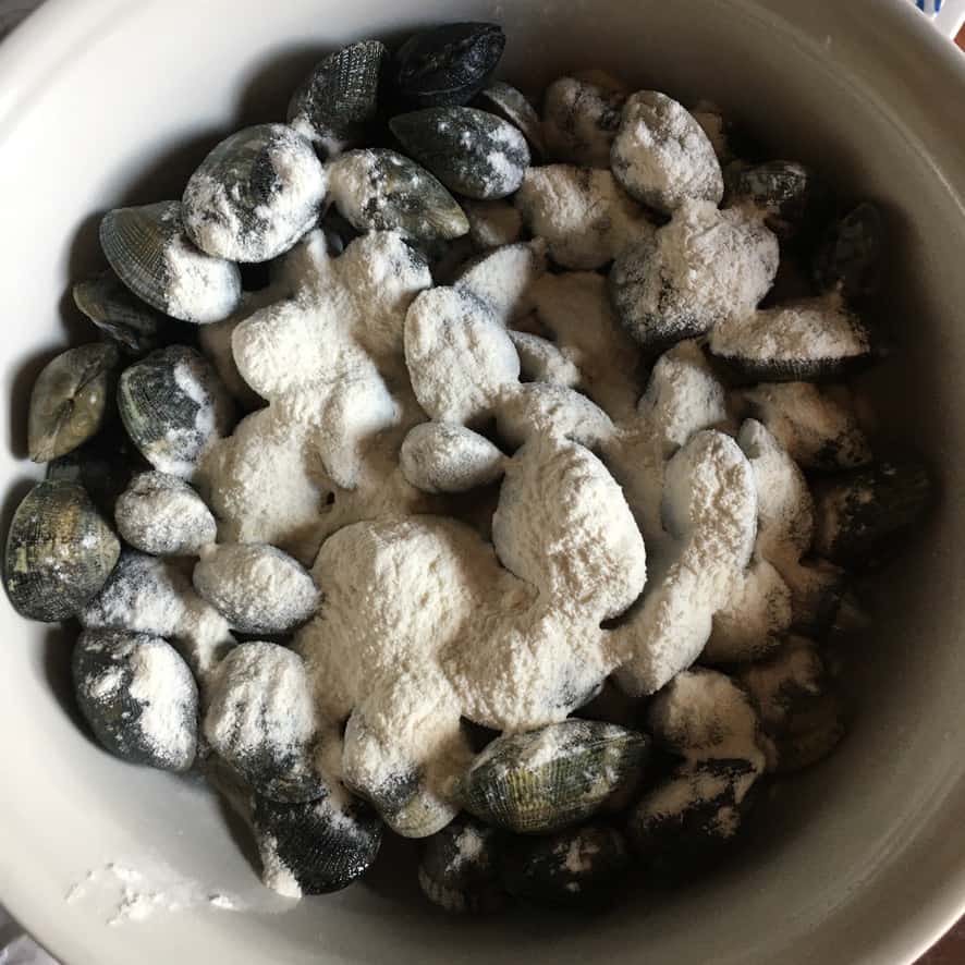 Step 4: Clams beginning to open in white wine clam sauce, shells cracking one by one in the steaming pan.