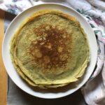 a plate full of green crepes stacked on top of one another