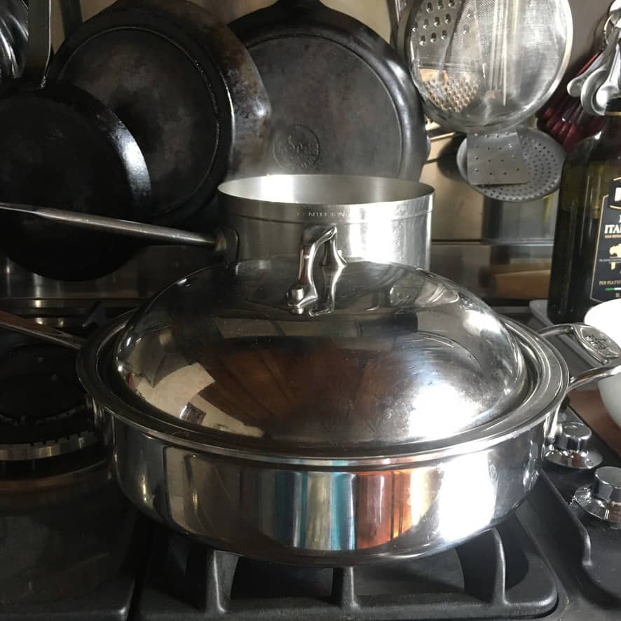 Clam pasta step-by-step: removing opened clams to a bowl with tongs to prevent overcooking.