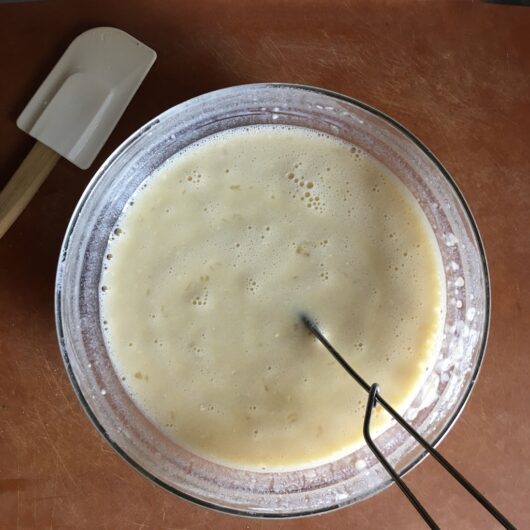 all the crepe batter ingredients after being whisked showing bubbles forming on top