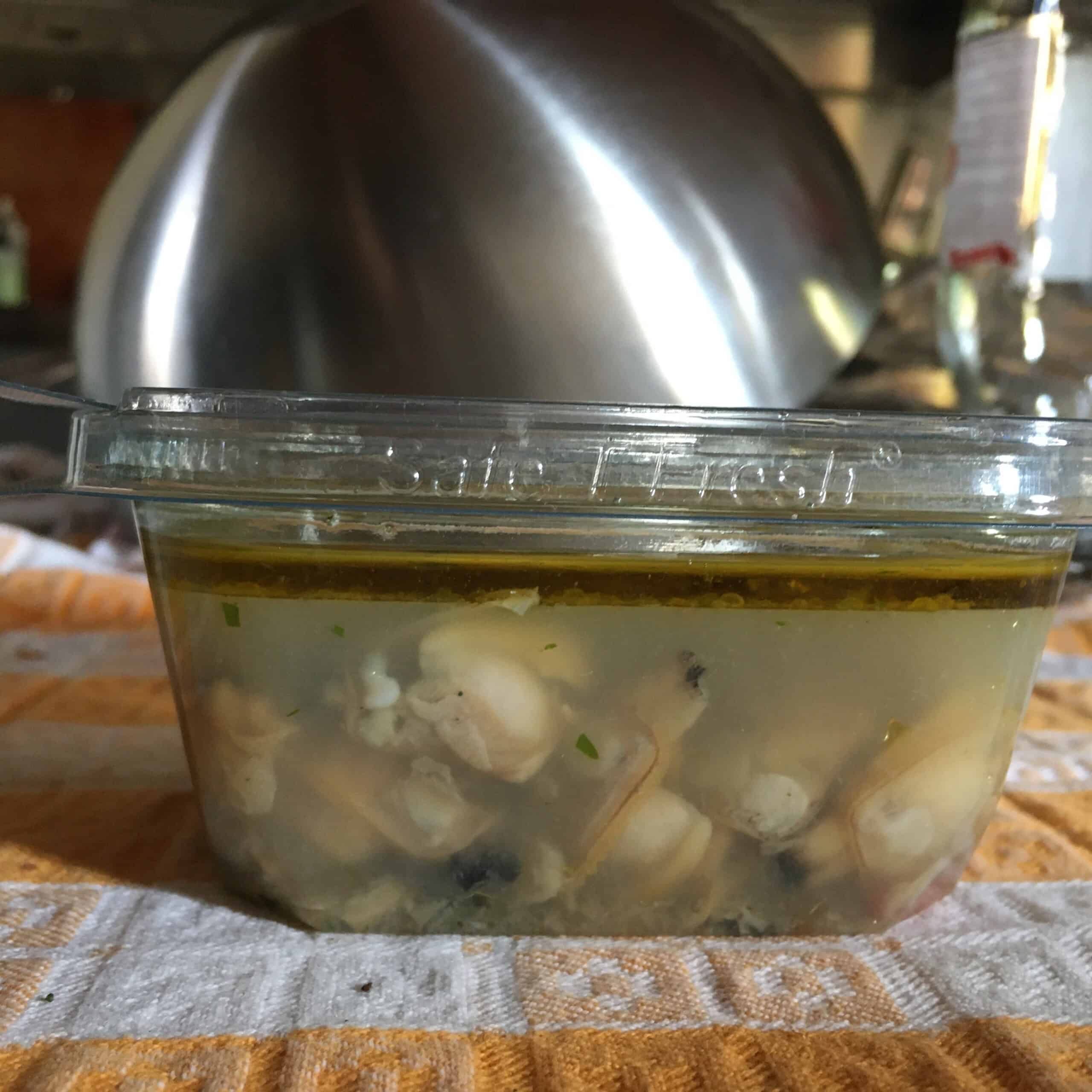 Container of make-ahead clam sauce with fresh clams ready to refrigerate or freeze for easy weeknight clams and pasta.