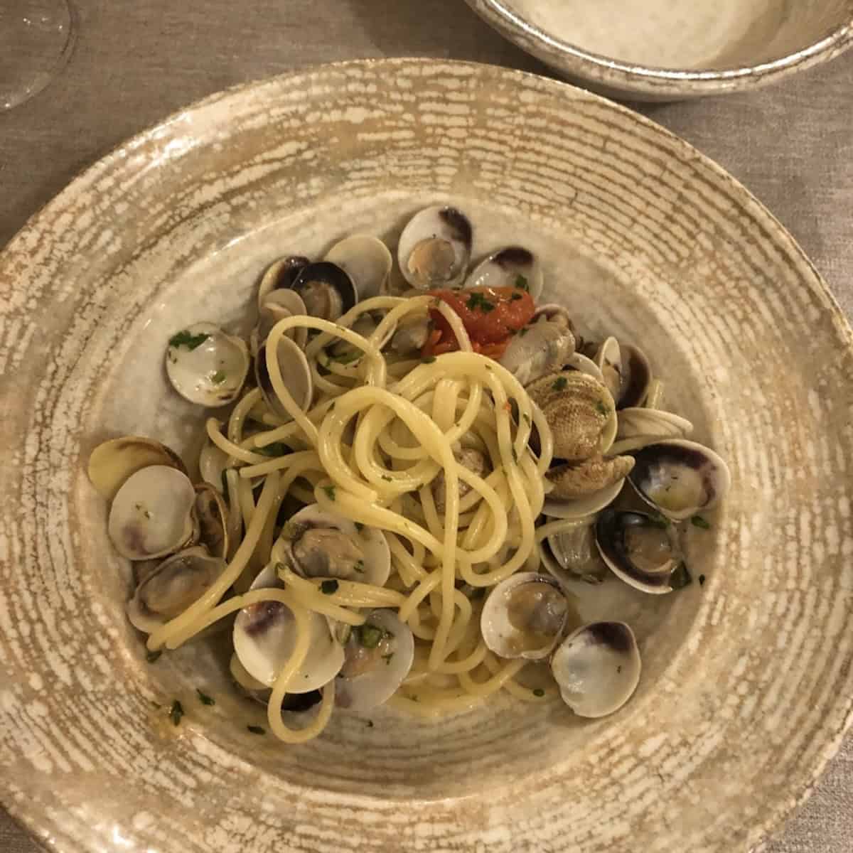 Spaghetti alle vongole from a seaside restaurant in Marche Italy, clam sauce pasta with fresh vongole clams.
