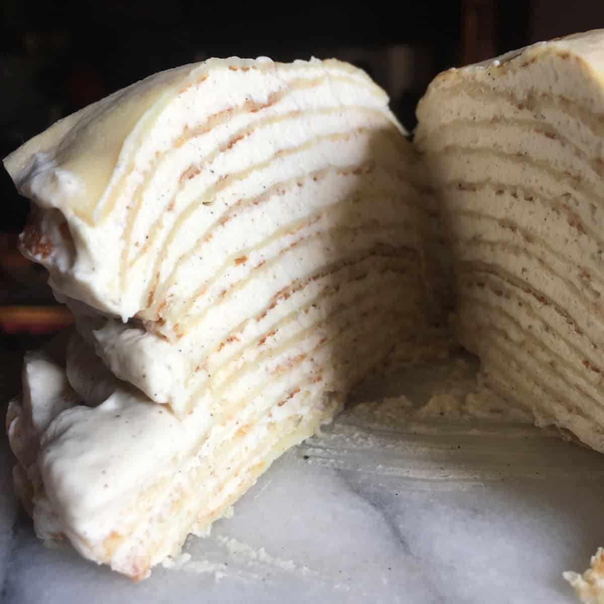 Interior slice of a homemade mille crepe cake showing layers of crepes and crepe cake filling for this crepe cake recipe.
