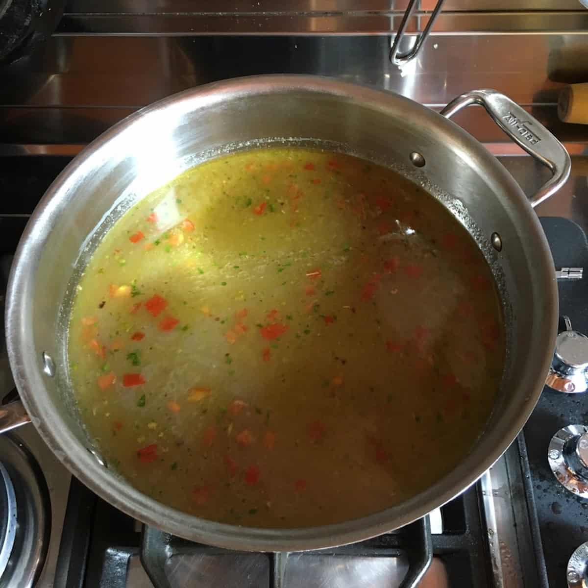 All-Clad saute pan with red clam sauce in rosso and chopped datterini tomatoes ready for pasta, linguine with red clam sauce variation.
