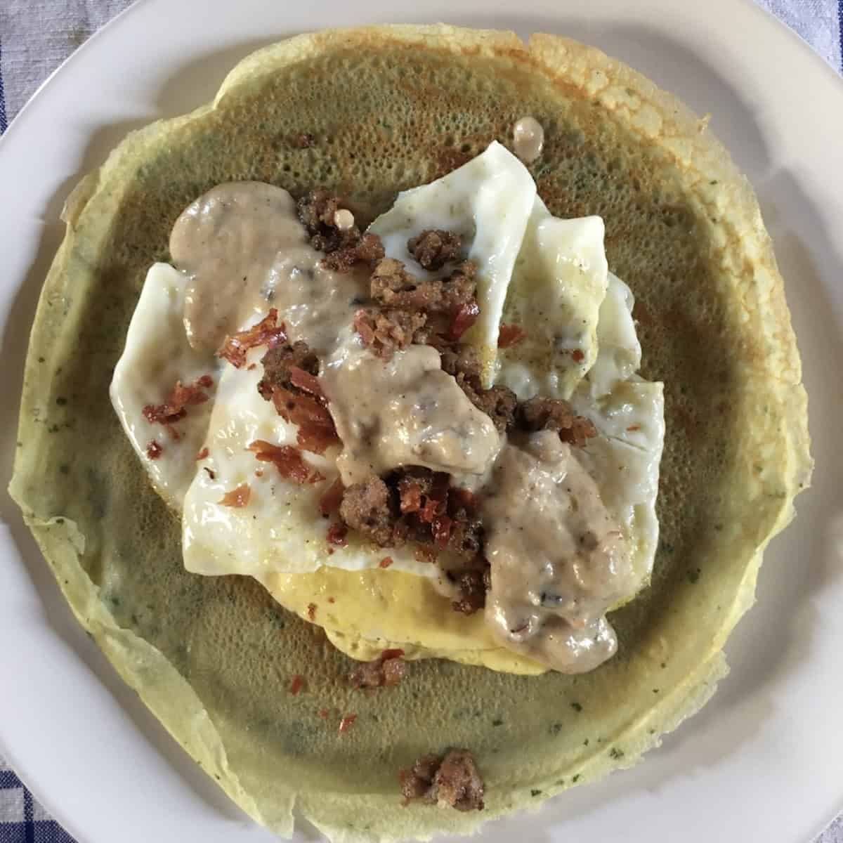 Savory breakfast crepes filled with eggs, sausage crumbles, and gravy, a hearty crepe filling recipe and savory crepe fillings idea for breakfast crepes.