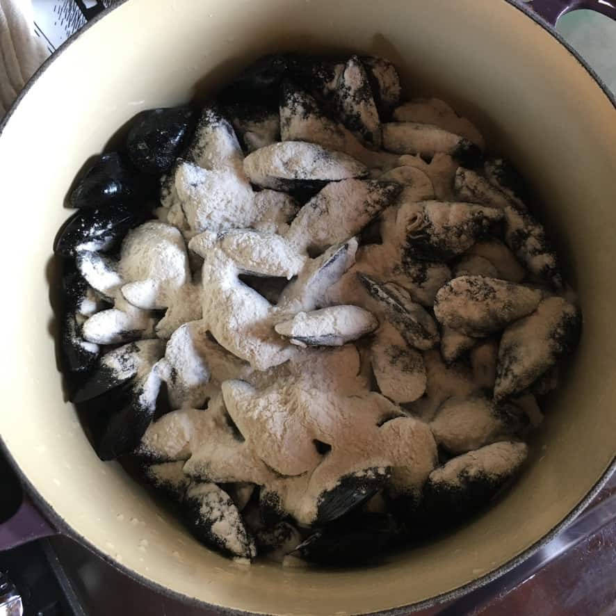black mussels with flour sprinkled over the top in a bowl