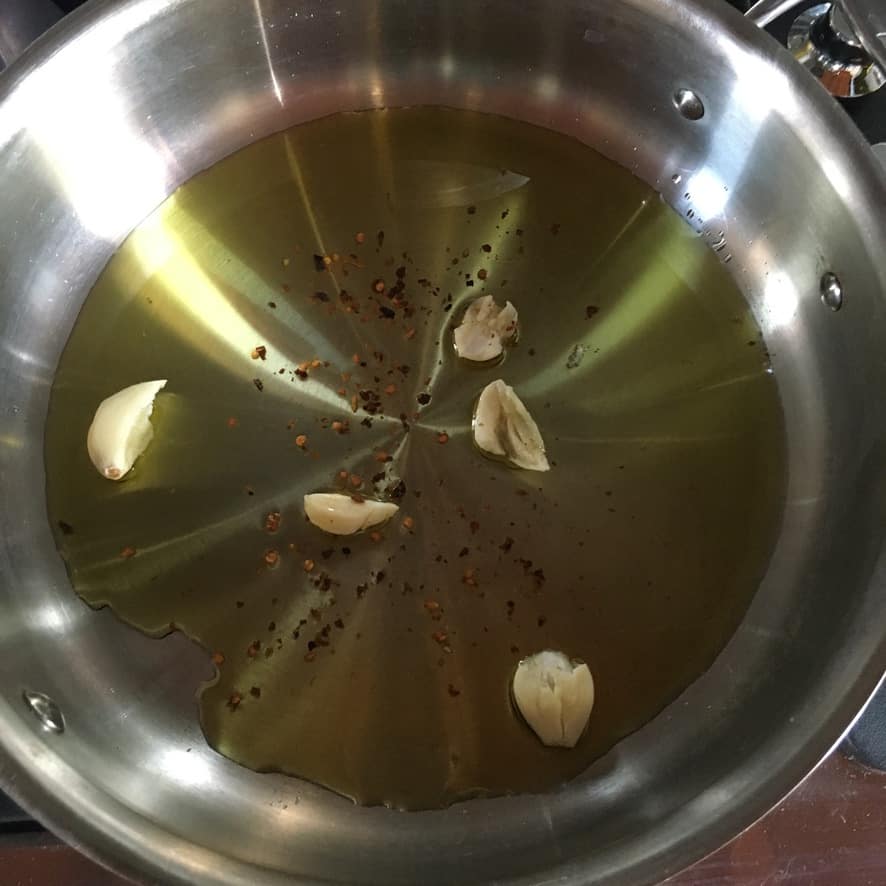 a pan with EVOO and garlic cloves