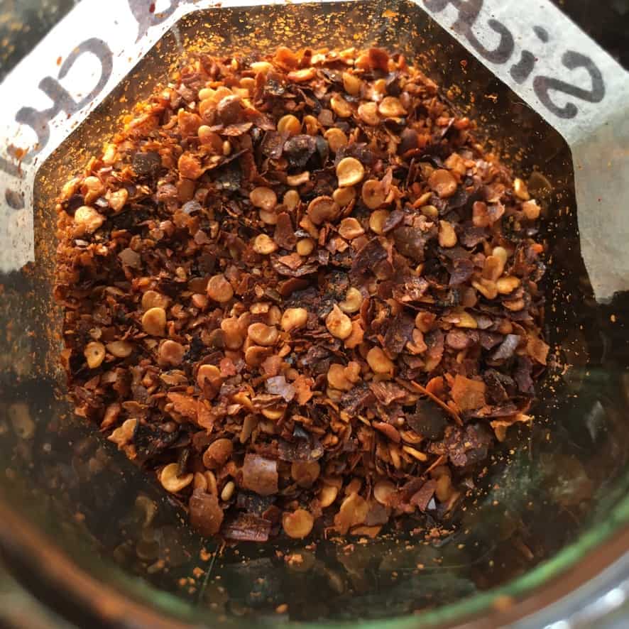 a view looking into the glass jar holding the Sichuan crushed red chili peppers