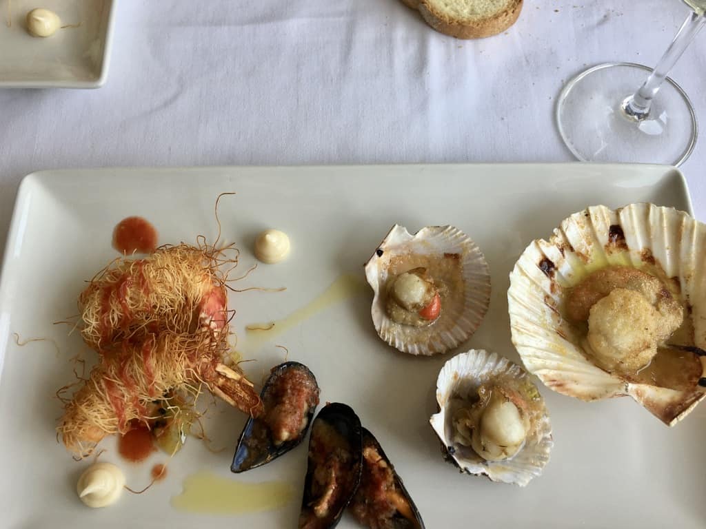 scallops and other seafood on a white platter at one of our favorite restaurants