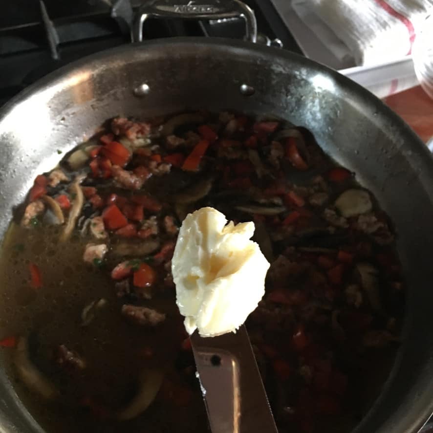 adding a pat of butter to finish the sauce