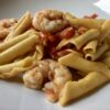 closeup of garganelli egg pasta noodles in a shrimp and tomato sauce