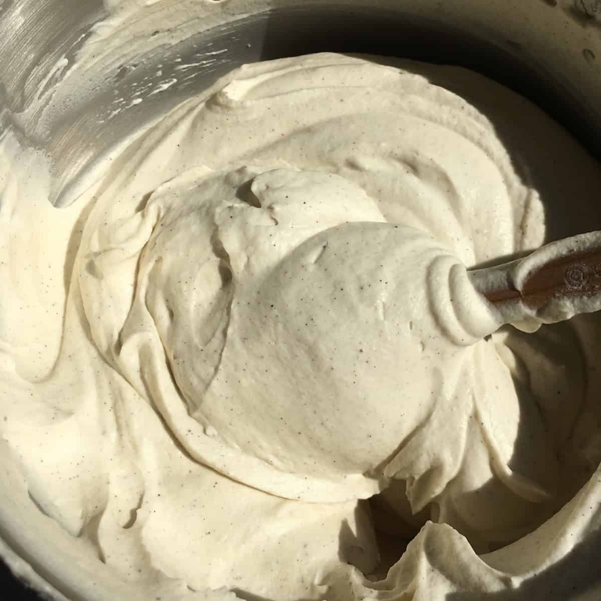 Homemade vanilla bean cream cheese frosting in a bowl for devil's food cake with cream cheese frosting, the best frosting for chocolate cake and devils food cake recipes.