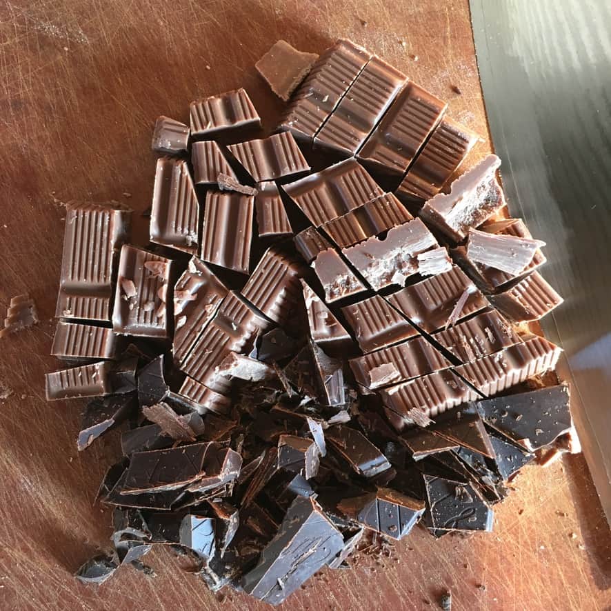 dark chocolate and milk chocolate bars chopped on a cutting board