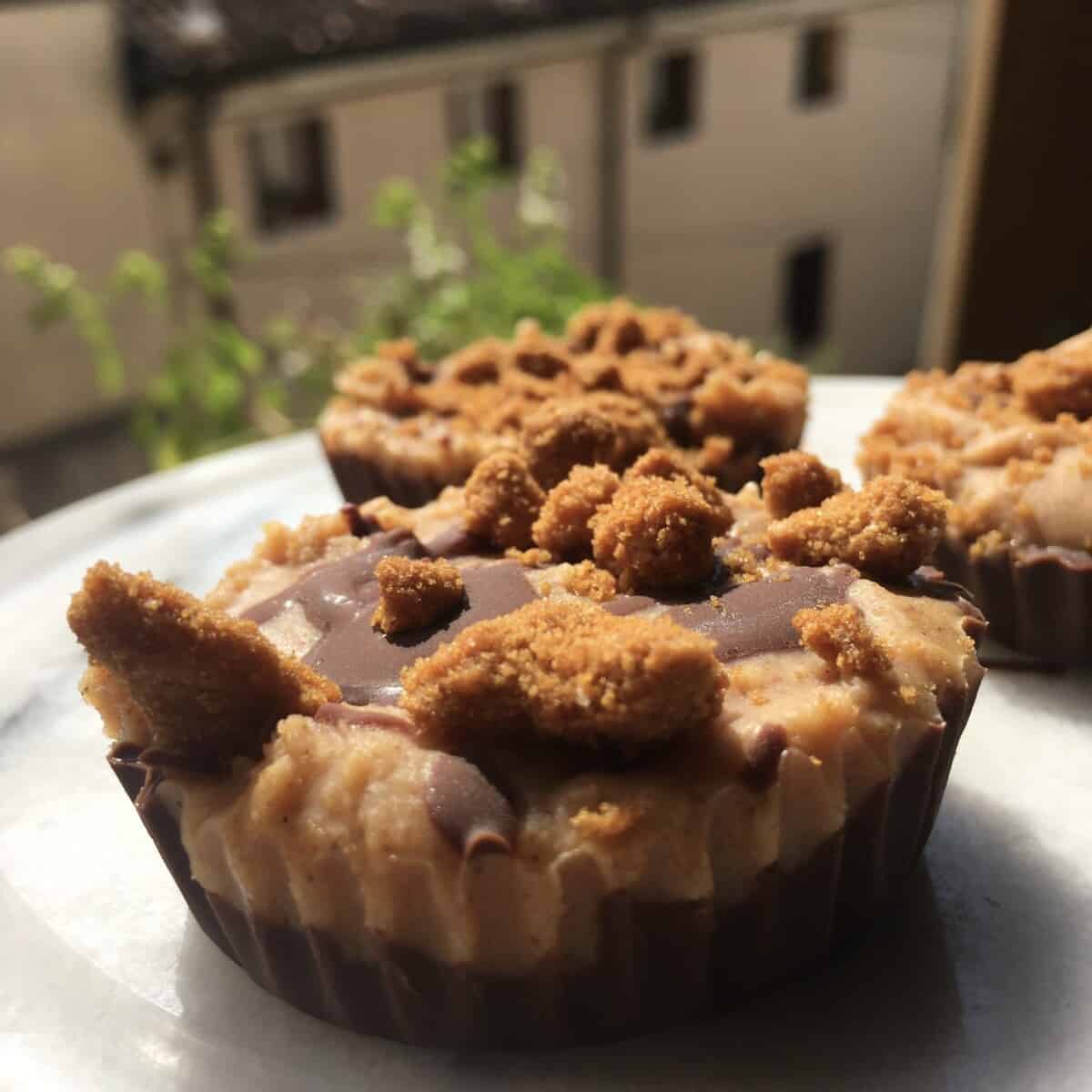 homemade peanut butter cups on a marble surface in the sunlight with a view out of the window