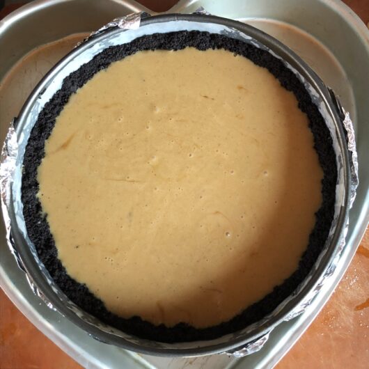 caramel-colored cheesecake batter in a springform pan about to be baked
