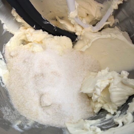 cream cheese and sugar added to the bowl of a stand mixer
