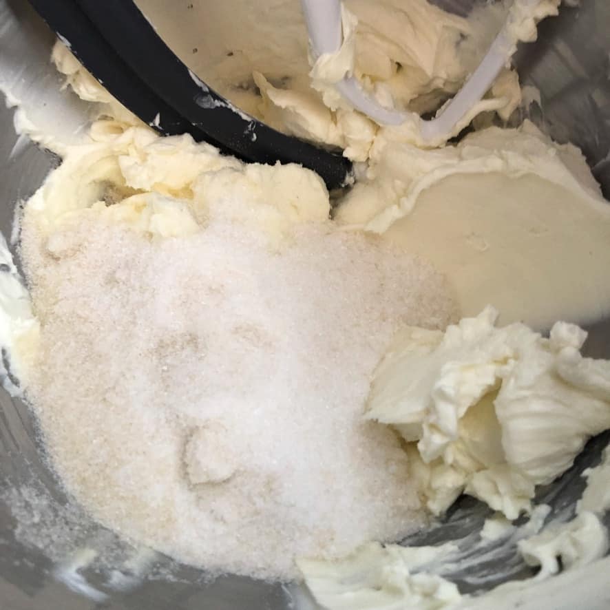 Cream cheese and sugar in the bowl of a stand mixer.