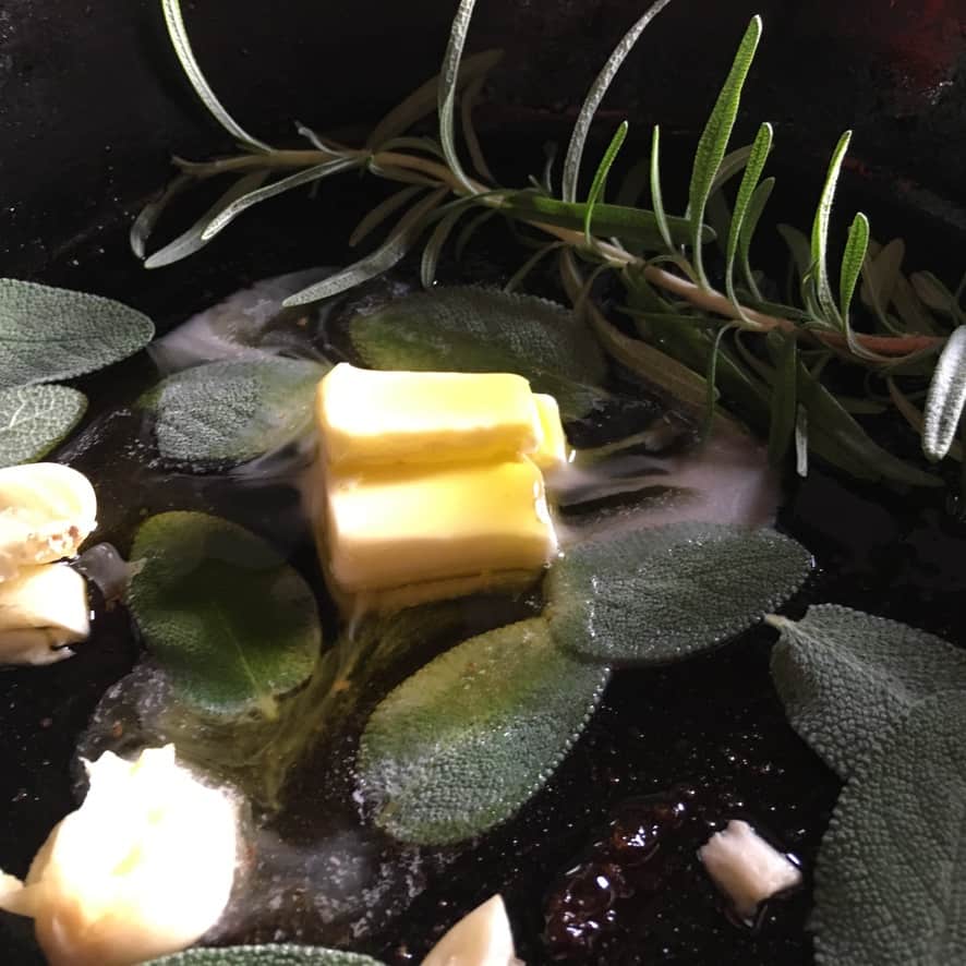 fresh herbs, butter, olive oil, and duck fat in a cast iron skillet