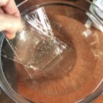 placing 2 gelatin sheets into a bowl of cold water