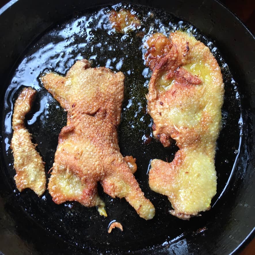 golden duck skin frying in the skillet