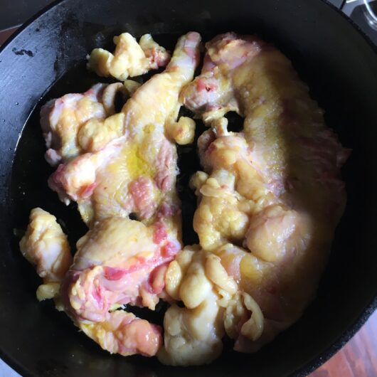 duck skins and fat rendering in a cast iron skillet