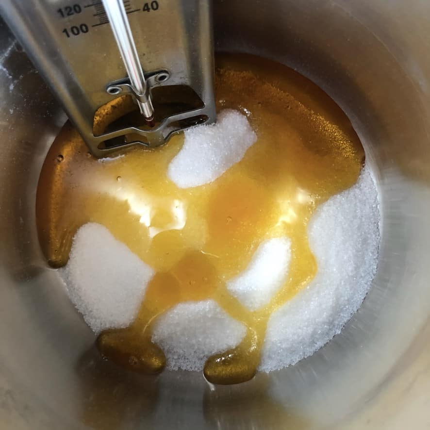a pot with lyle's golden syrup and sugar with a candy thermometer in it