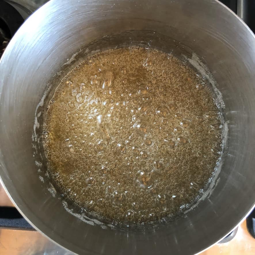 Caramel turning pale gold with small bubbles.