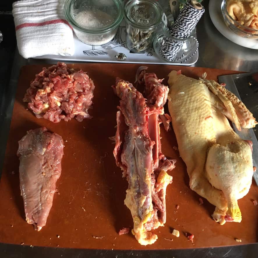 skinned pieces of half of a duck lying next to a duck half with skin still on