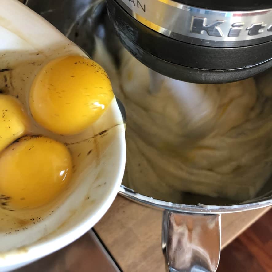Adding eggs to the cheesecake filling.