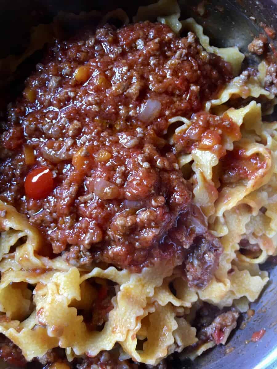 classic beef ragù with regginelle tagliatelle pasta in a pot