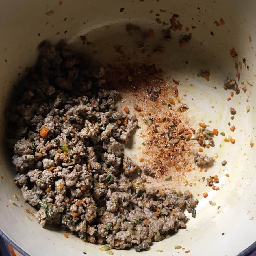 cooked duck meat and the brown fond on the bottom of the dutch oven