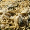 closeup of a braiser dish filled with spaghetti with zucchini and Grana Padano cheese