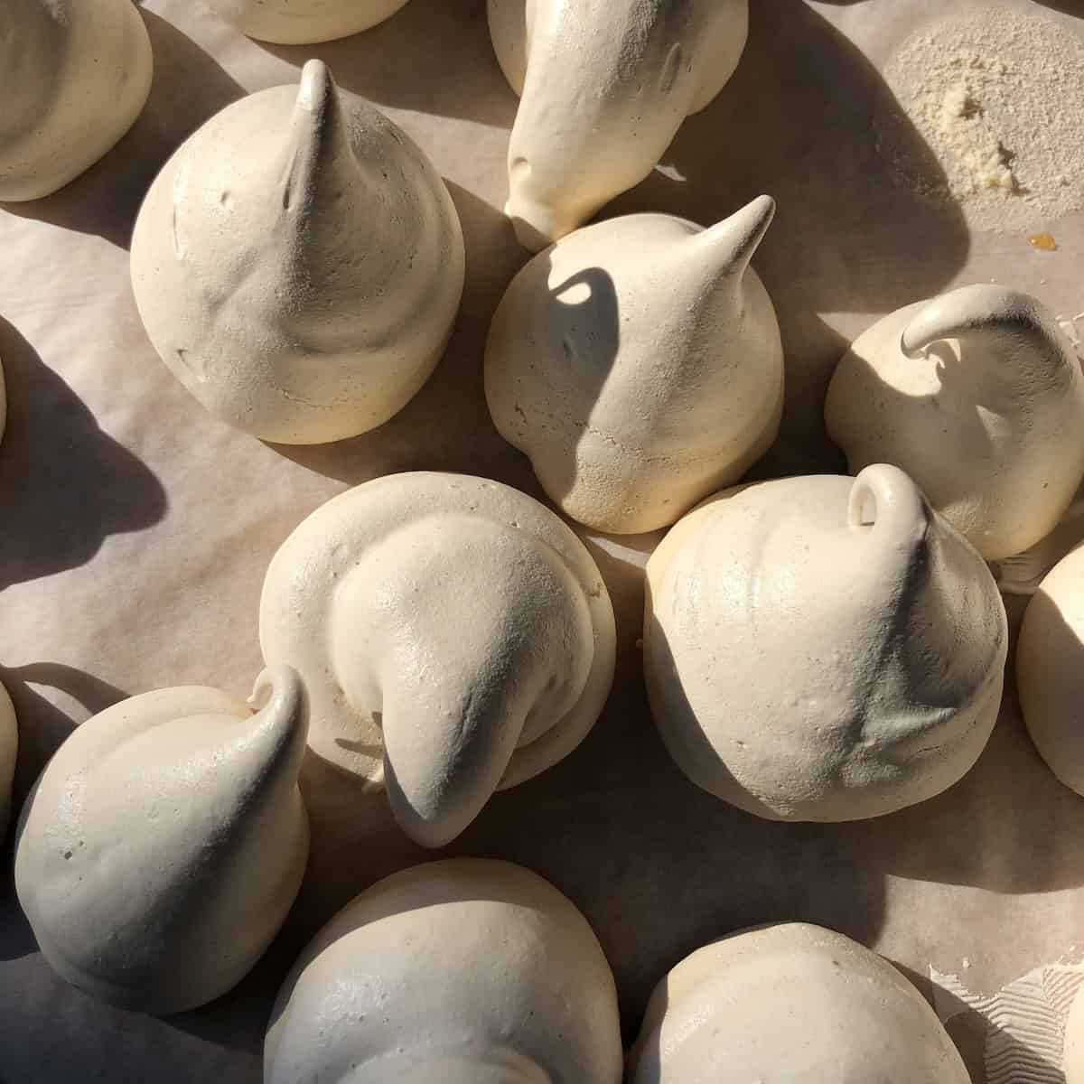 Fully baked undecorated halloween ghost meringue cookies.