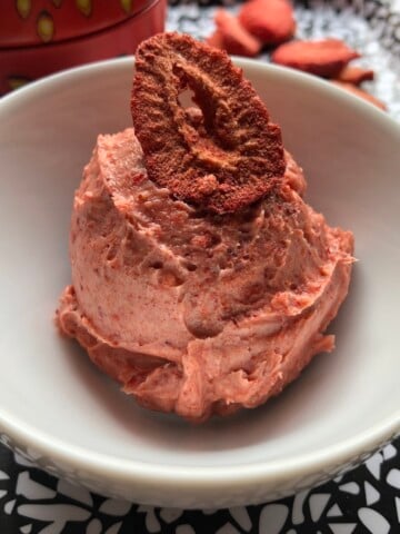 Strawberry butter in a bowl (looking like a scoop of ice cream) with a freeze dried strawberry garnish.