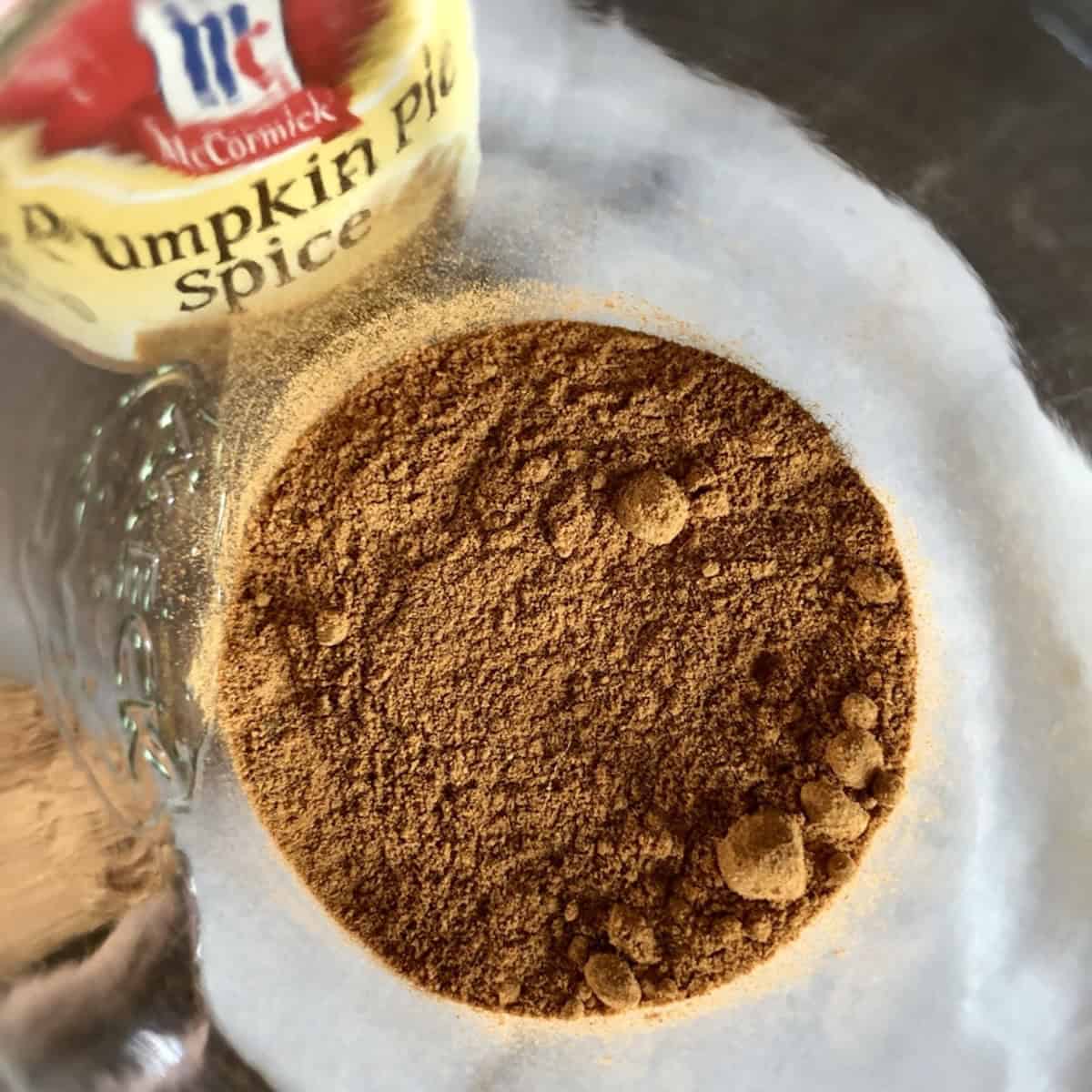 Homemade pumpkin pie spice recipe in glass weck jar with McCormick pumpkin pie spice bottle, how to make pumpkin pie spice blend from scratch, pumpkin spice mix substitute ingredients.