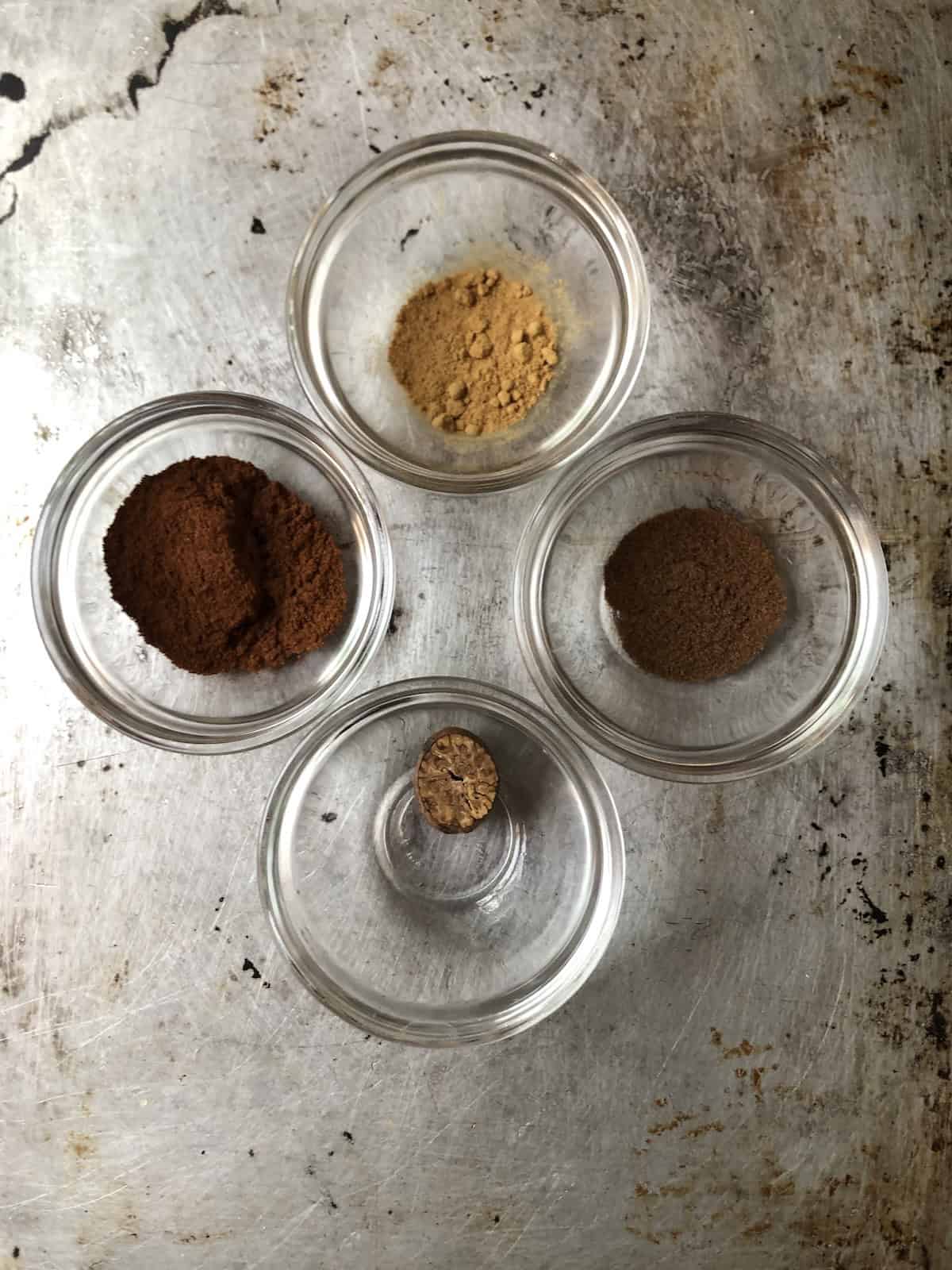Pumpkin pie spice ingredients in bowls cinnamon ginger allspice nutmeg seed, what spices are in pumpkin pie spice homemade blend recipe.