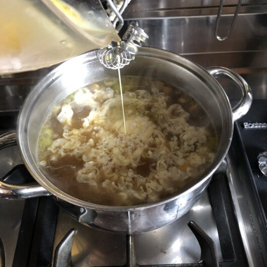 adding eggs to thickened egg drop soup base