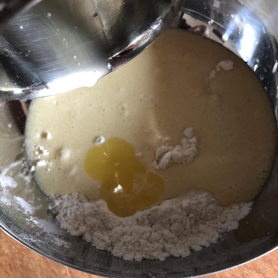 pouring melted butter into pancake batter
