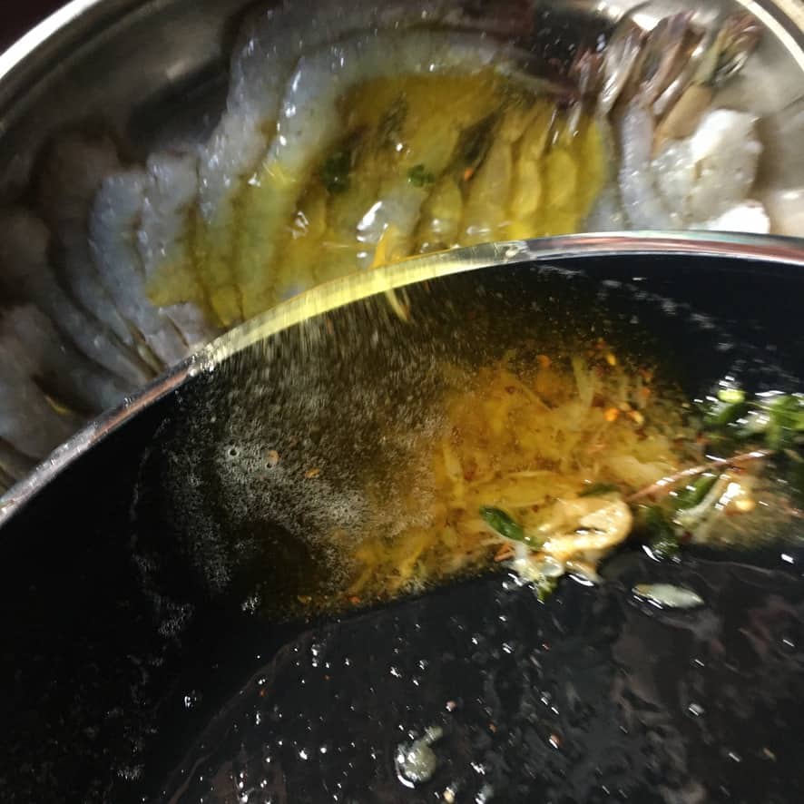 adding garlic butter scampi sauce to shrimp