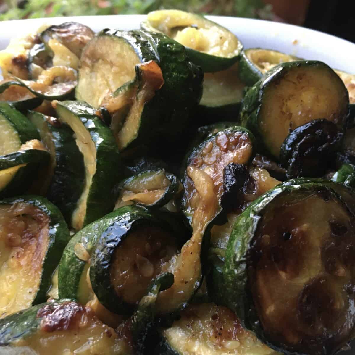 closeup pan-seared caramelized and golden brown zucchini rounds cooked a little past al dente