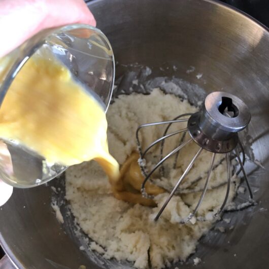 adding egg and extract to creamed butter and sugar
