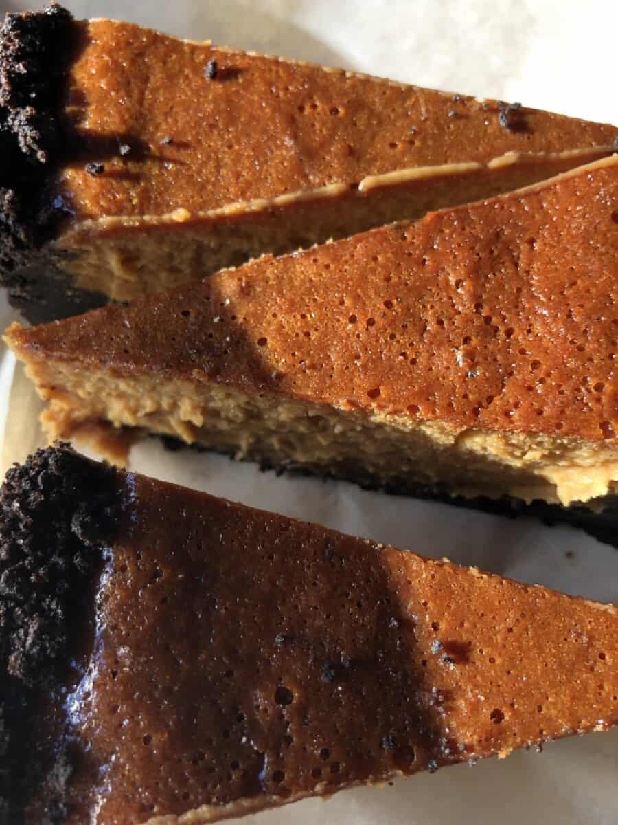 3 slices of cheesecake with the sun hitting them and looking deep amber in color