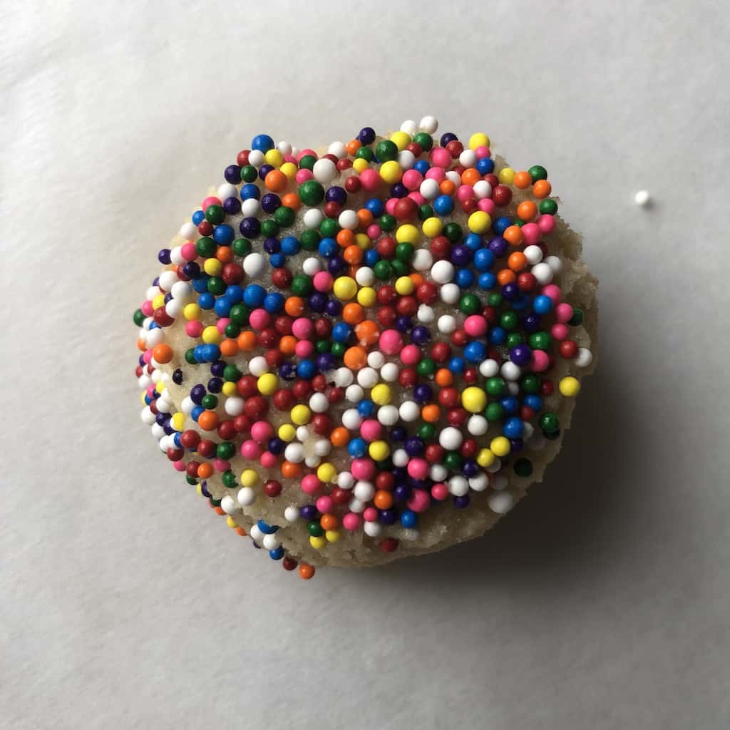 a single sugar cookie dough ball covered with nonpareils