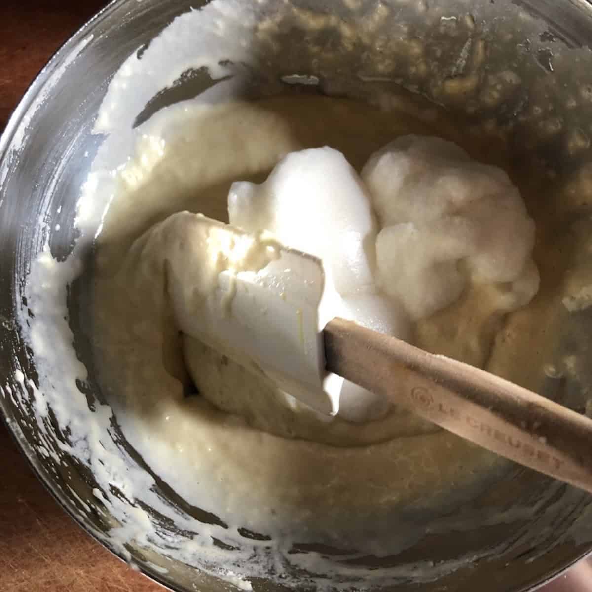 Folding whipped egg whites into the pancake batter with a rubber spatula until just combined,