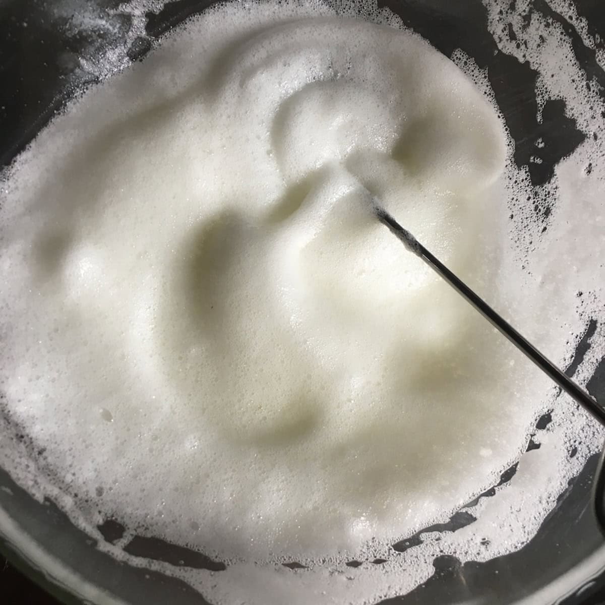 A bowl of properly whipped egg white at stiff peaks ready to fold into the pancake batter for extra fluffy pancakes.
