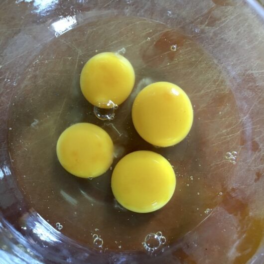 4 large eggs cracked in a mixing bowl