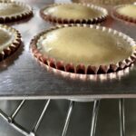 just baked and still puffy mini vanilla bean cheesecakes in a muffin tin